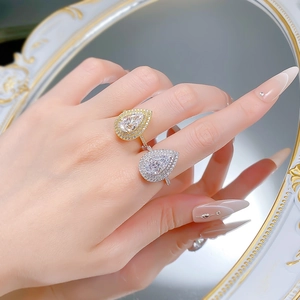 Detailed close-up of pear-cut sparkling cubic zirconia rings in gold and silver finishes