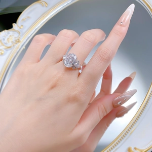 Detailed view of an oval cut carbon diamond ring with bow accents on a hand model