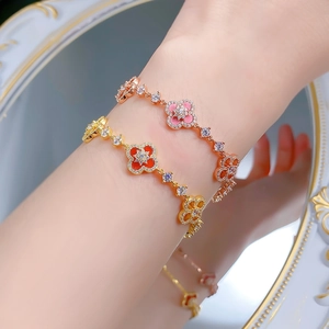 Macro detail of S925 silver four-leaf clover bracelets with red and pink inlays on wrist