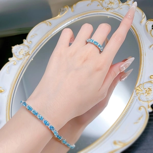 Detailed view of silver S925 bracelet and ring set with blue oval-cut gemstones