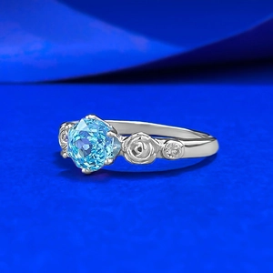 Elegant rose-etched silver ring with a 1-carat round blue gemstone and side diamonds