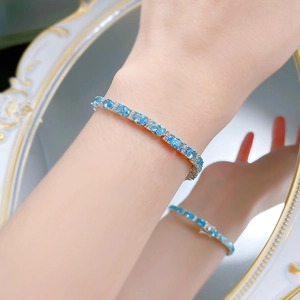 Close-up of S925 silver tennis bracelet with oval blue stones worn on a female wrist