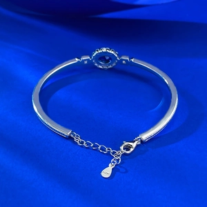 Detail of S925 sterling silver bangle featuring a royal blue gemstone with adjustable chain