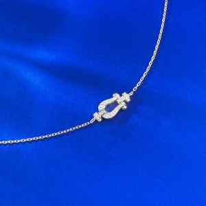Macro view of silver horseshoe buckle bracelet with pavé diamonds on blue fabric