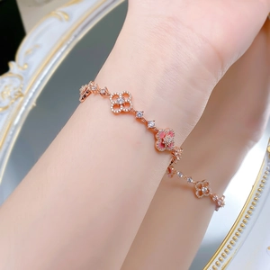 Close-up of elegant rose gold clover bracelet with pink enamel and zircon details