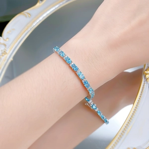 Macro shot of S925 silver bracelet with oval-cut aquamarine stones on a wrist