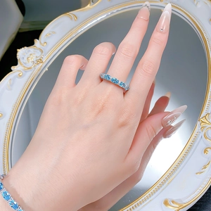 Detail of S925 silver ring set with oval aquamarine gemstones worn by a model