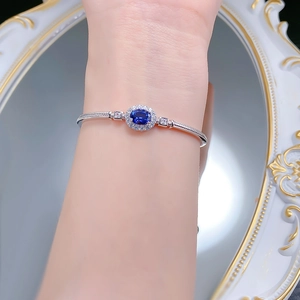 Detail of S925 silver bracelet with oval royal blue gemstone and halo setting