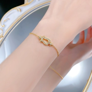 Macro shot of silver horseshoe bracelet with sparkling zircons worn by a female model
