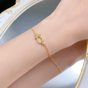 Macro shot of gold horseshoe buckle bracelet with pavé zircons on model wrist