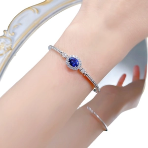 S925 silver open bracelet featuring an oval royal blue sapphire in a halo diamond setting