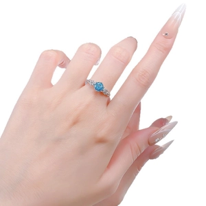 Elegant rose gold ring with a round light blue gemstone and intricate flower carvings
