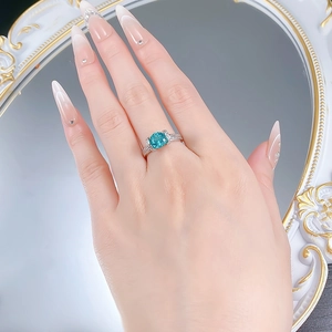 Détail d'une bague en argent S925 avec pierre bleue et diamants dans le reflet du miroir