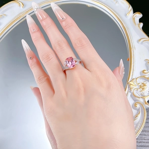 Gros plan d'une bague en argent S925 avec une pierre rose rectangulaire portée par un mannequin