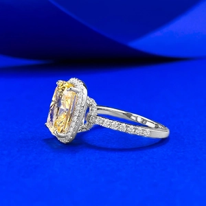 Macro side view of cushion cut yellow gemstone ring with diamond halo and pavé band