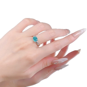 Bague élégante en argent S925 avec pierre bleue paraiba sur la main, fond blanc pur