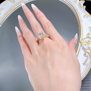 Close-up of a 9x12mm emerald cut lab diamond ring with gold band on a model hand