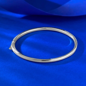 Macro shot of S925 silver hinged bracelet featuring pavé set sparkling gemstones on blue velvet
