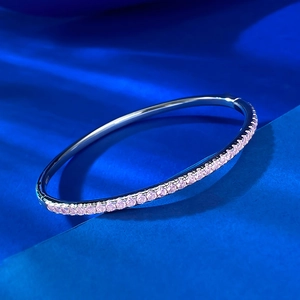 Elegant S925 sterling silver bangle with half-set pink zircon stones on blue texture