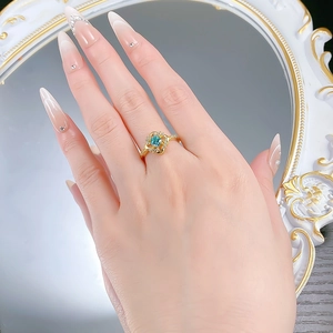 Gros plan sur la bague en argent S925 avec gemme bleue et détails floraux en diamant
