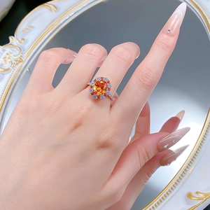 Bague en argent 925 portée au doigt avec une pierre orange de 4 carats et entourage floral