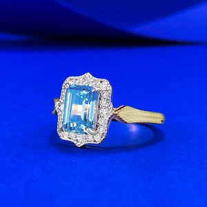 Vintage gold ring featuring a rectangular light blue gemstone with a diamond halo