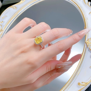 Close-up of S925 silver ring with radiant yellow cushion-cut stone and diamond halo