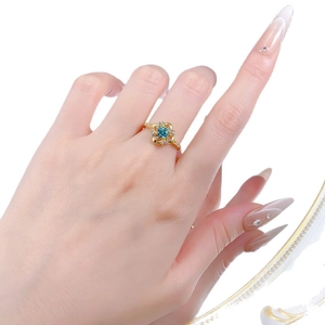 Bague en argent S925 avec pierre bleue-verte et motif fleur portée par un modèle