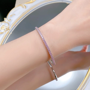 Detail of S925 silver bangle with pink cubic zirconia stones on a model wrist
