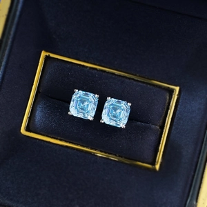 Sky blue 7x7mm square cut gemstones in silver four-prong stud earrings inside a jewelry box
