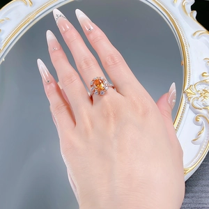Détail d'une bague en argent 925 avec une pierre orange ovale et un sertissage de diamants