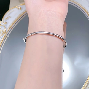Close-up of a sleek S925 silver minimalist polished bangle worn on a model's wrist