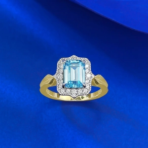 Macro shot of 925 silver ring featuring emerald-cut blue stone and halo diamonds