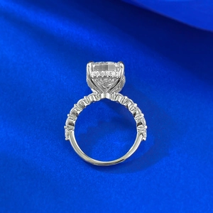 Makroaufnahme von Radiant-Diamantring mit Pavé-Fassung auf blauem Seidenhintergrund