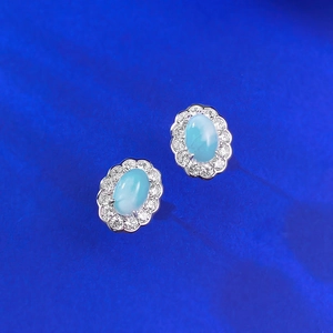 Macro detail of S925 silver stud earrings with oval Larimar stone and zircon halo