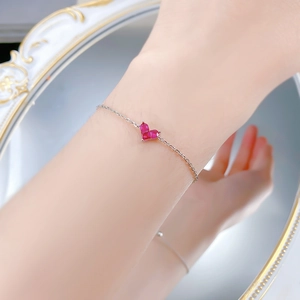 Détail du bracelet en argent S925 avec pendentif cœur rose porté au poignet délicat