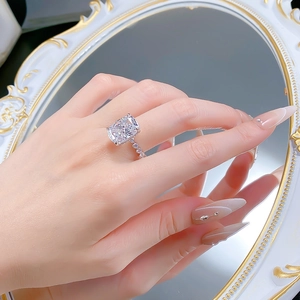 Nahaufnahme eines großen Radiant-Schliff-Diamantrings mit seitlichem Besatz an der Hand