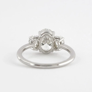 Macro detail of an S925 silver oval cut three-stone engagement ring with side diamonds
