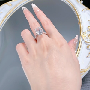 Nahaufnahme eines Radiant-Kissen-Silberrings mit Pavé-Diamantband an der Hand