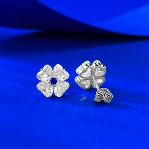Detailed macro view of S925 silver clover earrings with heart-shaped stones and blue center