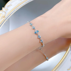 Close-up of S925 silver flower bracelet with blue stones and crystals on a wrist
