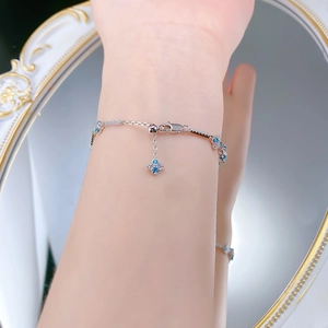 Detailed close-up of S925 silver bracelet with blue gemstones on a model's wrist