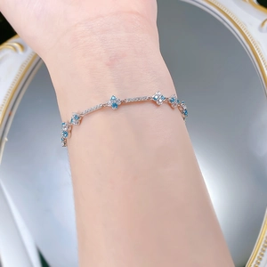Close-up of S925 silver bracelet with blue and white stones on a woman's wrist