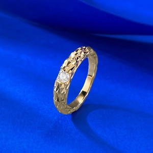 Macro detail of gold ring featuring 0.3ct moissanite and dragon scale textured band