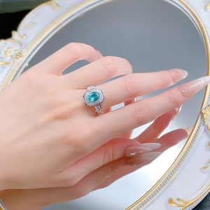 Détail de bague en argent 925 avec tourmaline paraïba et anneau chaîne sur modèle