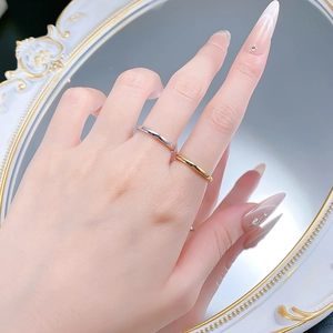Polished silver and gold minimalist stackable rings shown on model finger in a mirror reflection
