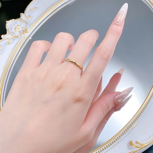 Close-up of minimalist glossy gold ring on index finger with vintage mirror background