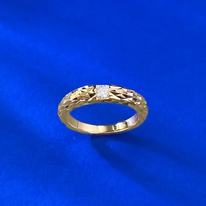 Macro detail of 925 silver moissanite ring with golden geometric dragon scale texture