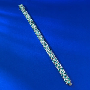 Detail of three-row S925 silver bracelet with inlaid green and white cubic zirconia