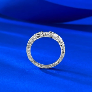 Macro shot of 925 silver moissanite ring with faceted geometric texture on a blue silk base
